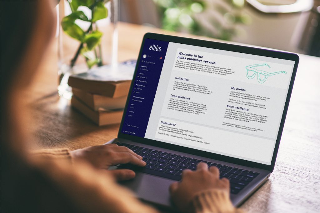 A person is using a laptop with the Ellibs publisher service open on the screen. In the background, there are books and a green plant on the table.