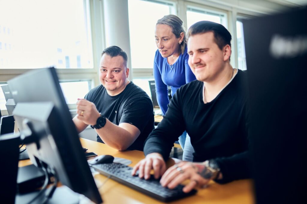 Opiskelijoita istumassa tietokoneiden ääressä